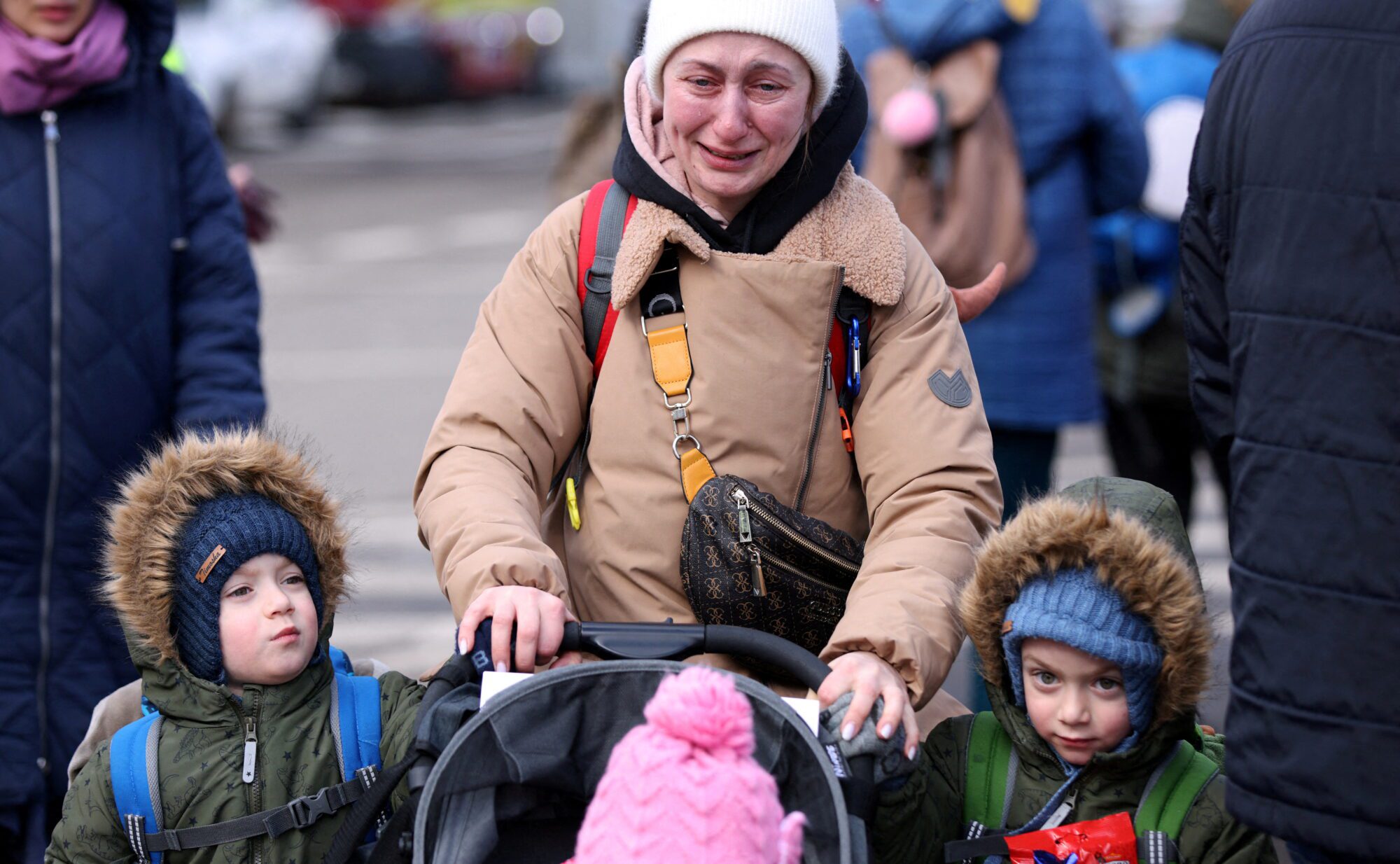 A woman cries next to her children last winter after fleeing from Russia's invasion of Ukraine, at the border crossing in Siret, Romania, February 28, 2022. REUTERS/Stoyan Nenov