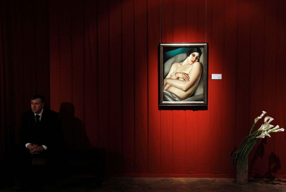 FILE PHOTO: A security guard sits next to a Tamara de Lempicka painting at Sotheby's preview of upcoming major Russian art auctions in New York and London, at the Russian Academy of Arts in Moscow October 19, 2011. REUTERS/Denis Sinyakov/File Photo