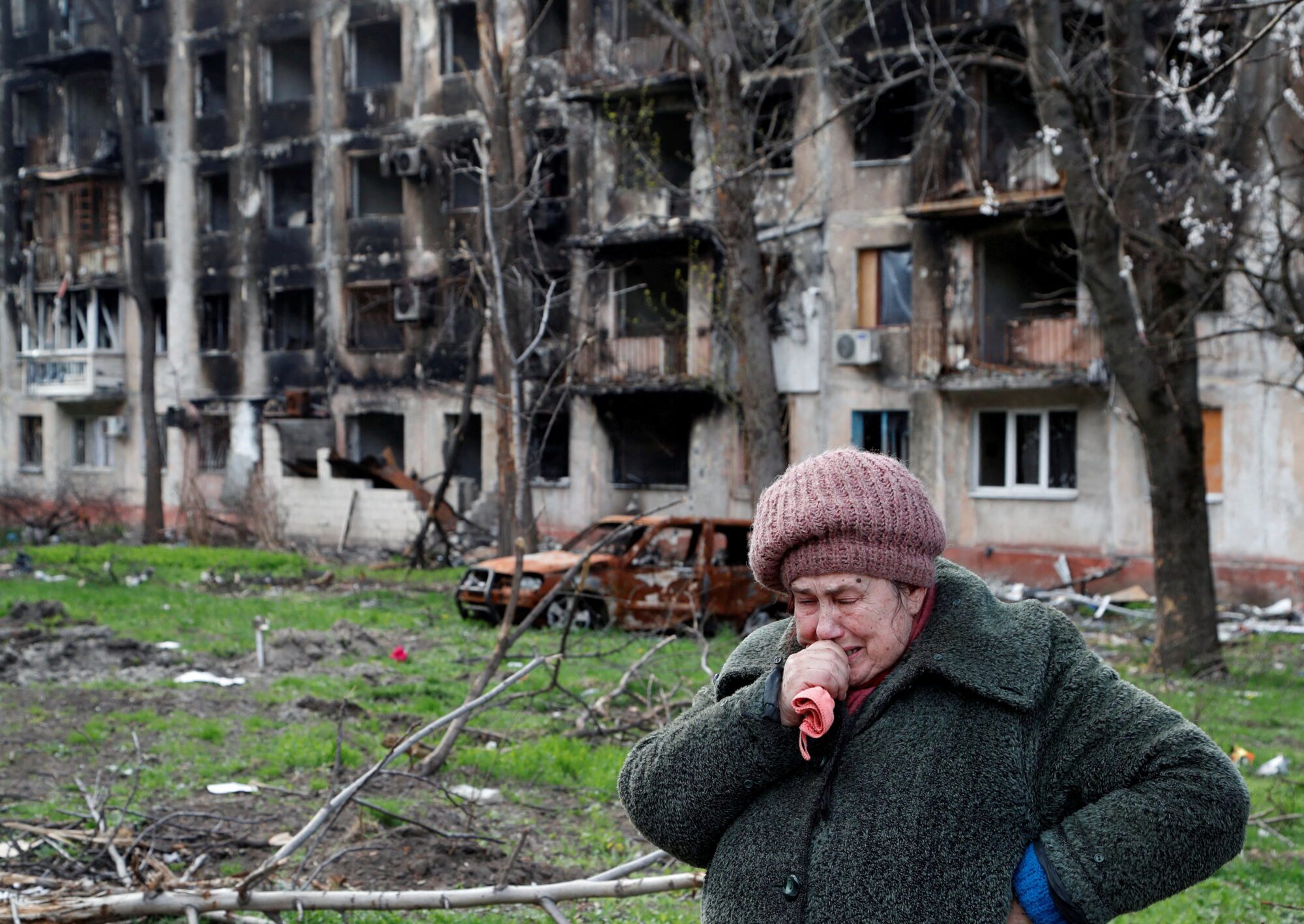 Local resident Tamara cries in front of a destroyed apartment building in Mariupol