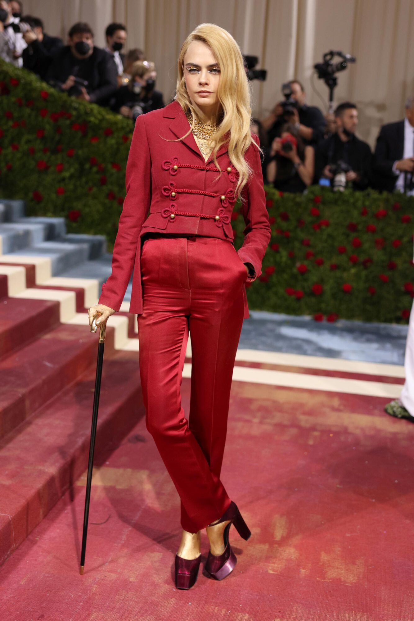Cara Delevingne wore a Dior Haute Couture Spring-Summer 2019 burgundy ottoman jacket with frogging and satin trousers. She also wore Dior jewelry.
