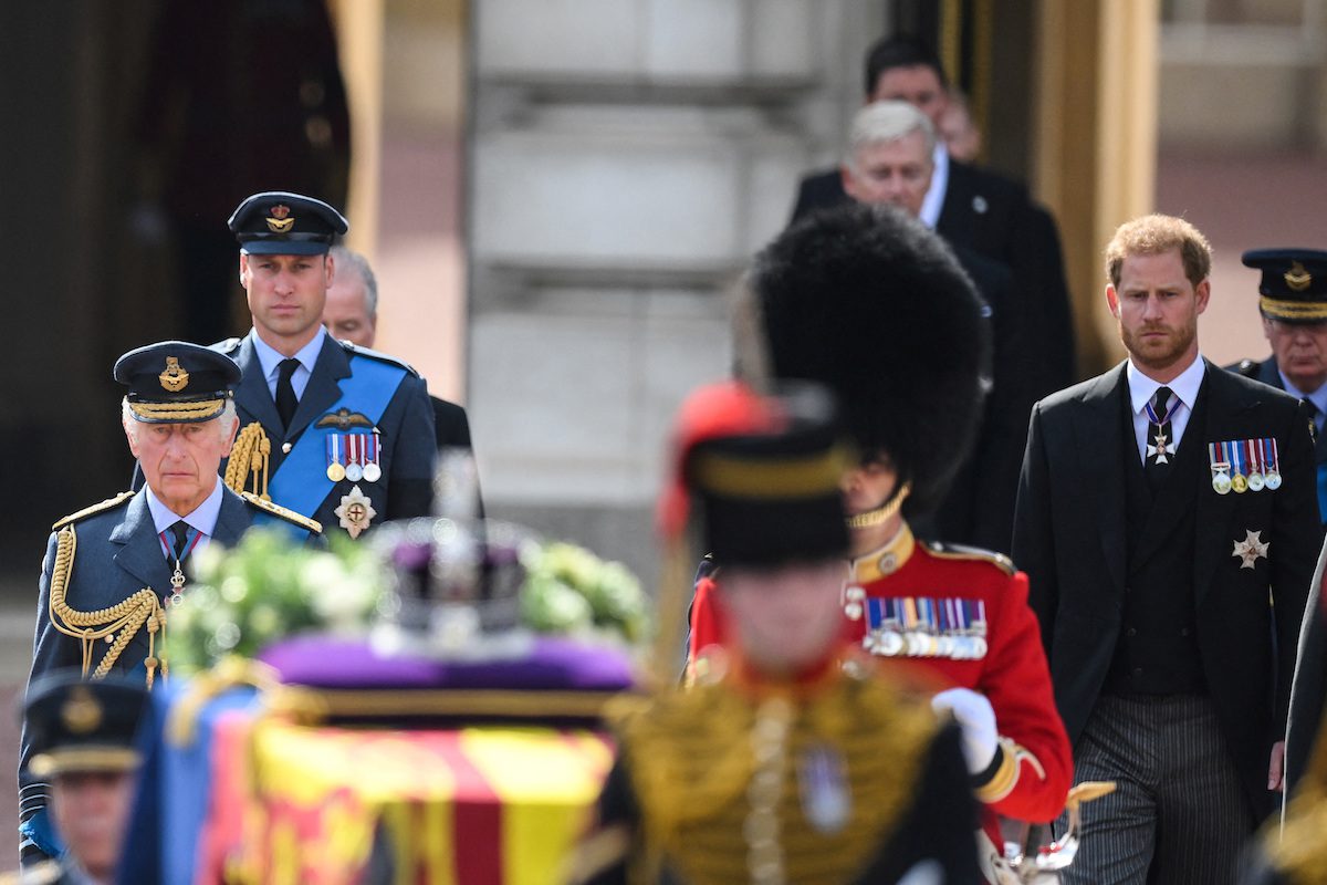 Britain's King Charles III (L), Britain's Prince William, Prince of Wales (2L) and Britain's Prince Harry, Duke of Sussex walk behind the coffin of Queen Elizabeth II, adorned with a Royal Standard and the Imperial State Crown and pulled by a Gun Carriage of The King's Troop Royal Horse Artillery, during a procession from Buckingham Palace to the Palace of Westminster, in London on September 14, 2022.  DANIEL LEAL/Pool via REUTERS
