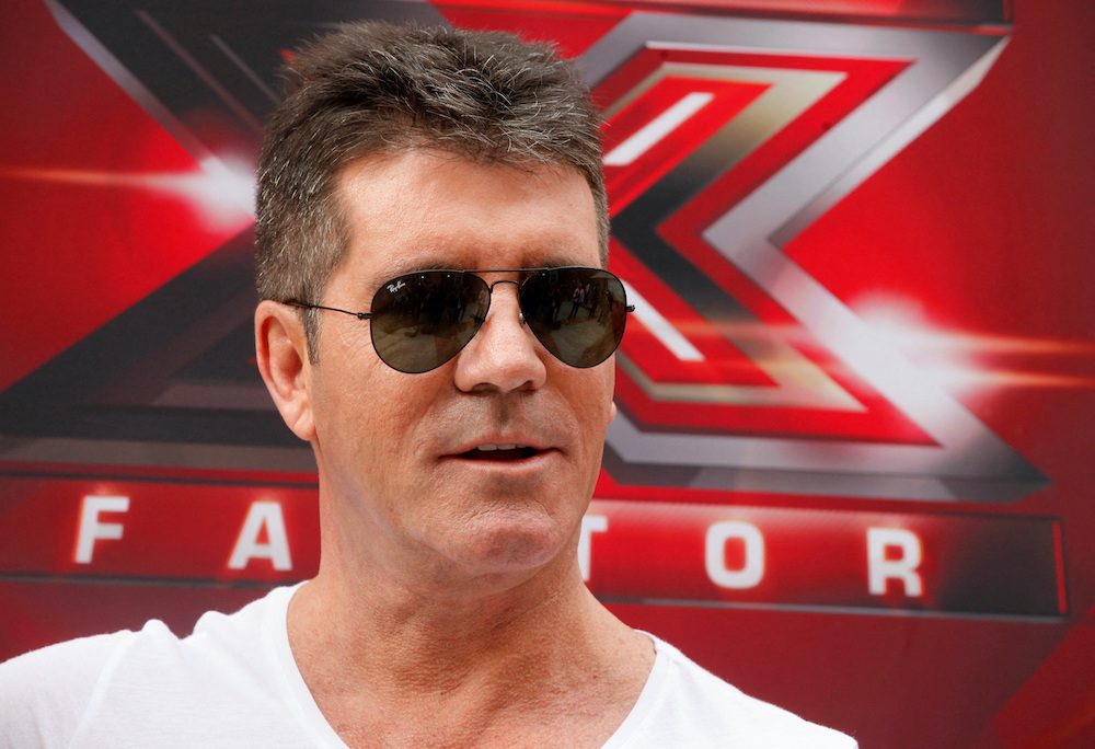 FILE PHOTO: Producer Simon Cowell and a judge for the upcoming season of the Fox television network reality series "The X Factor", poses during a photo opportunity in Los Angeles July 11, 2013. REUTERS/Fred Prouser/File Photo