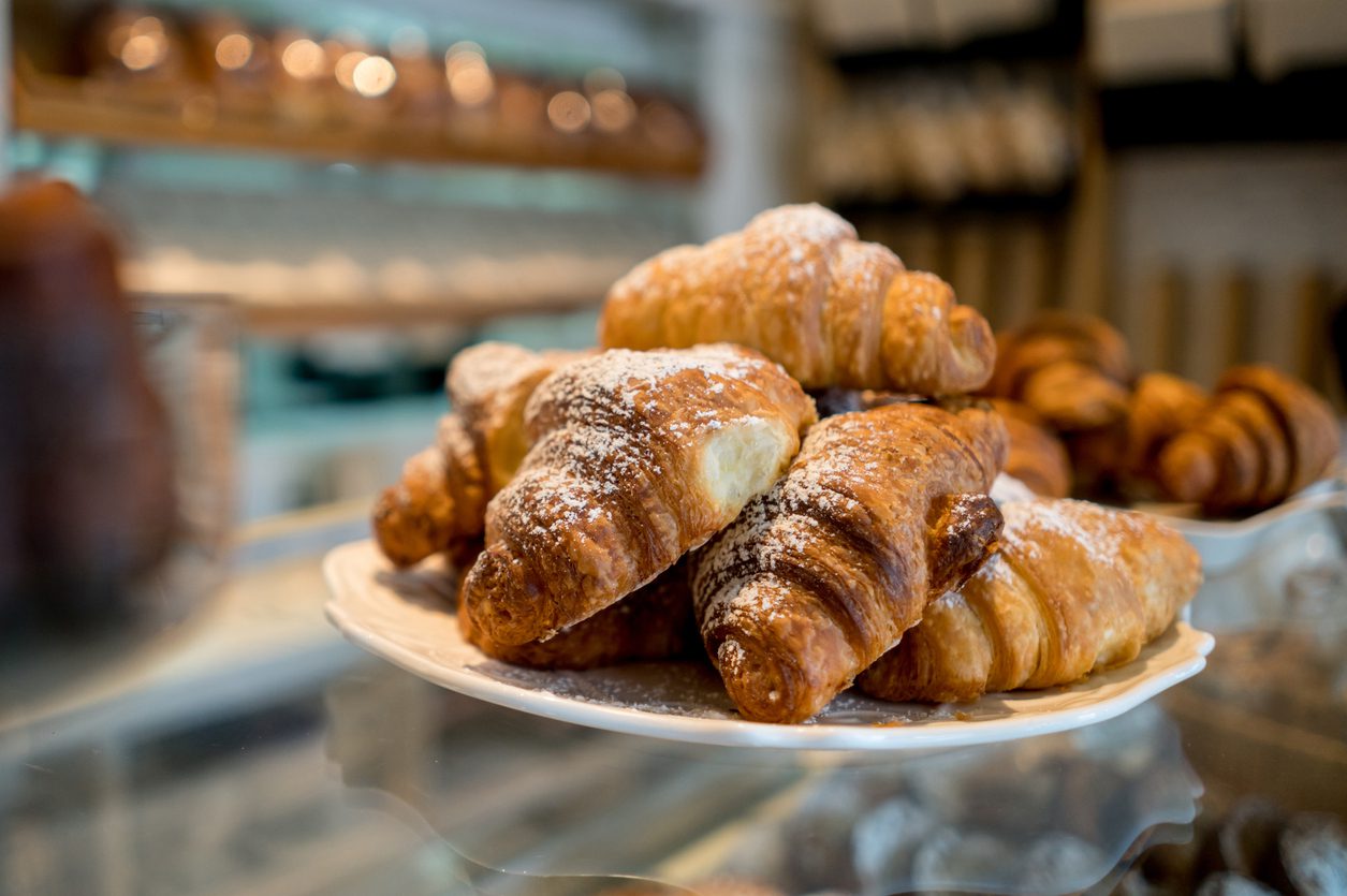 Close up of delicios croissants on the glass display at a bakery