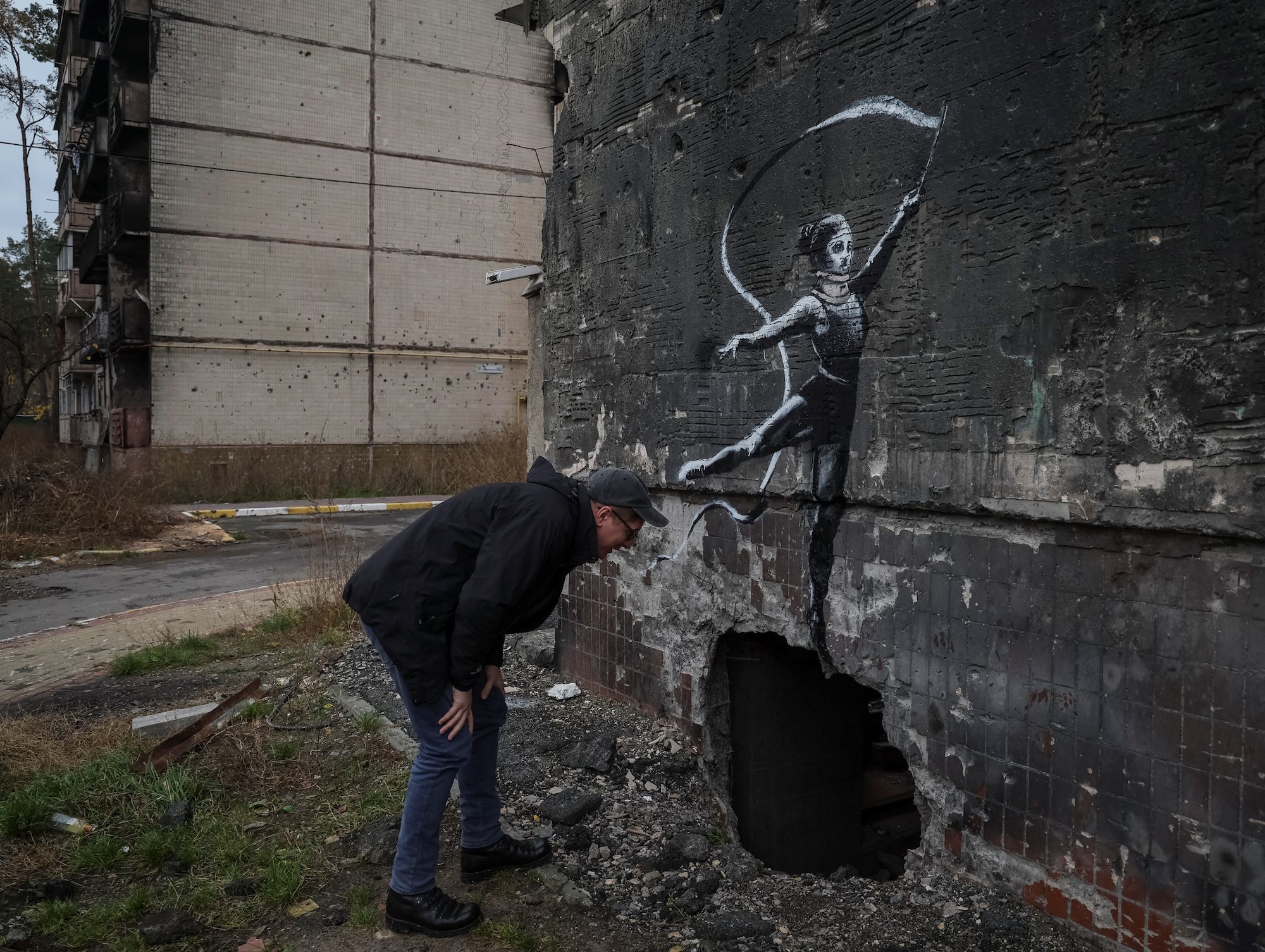 A new graffiti in Banksy's signature style, although not posted by the mercurial artist on social media, is seen at the wall of destroyed building in the Ukrainian town of Irpin, which heavily damaged by fighting in the early month of Russian invasion, November 12, 2022.  REUTERS/Gleb Garanich