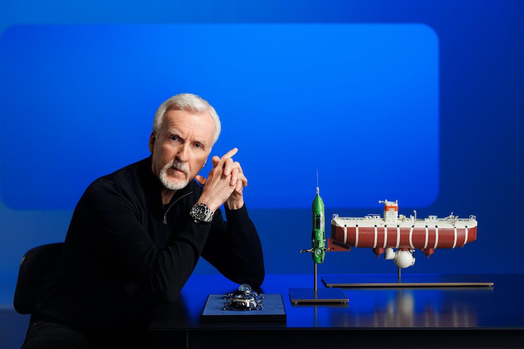 James Cameron, an Oyster Perpetual Deepsea Challenge
on his wrist, posing with a model of the bathyscaphe Trieste (right), his submersible DEEPSEA CHALLENGER (centre) and (left) the two experimental watches attached to the vehicles during the dives into the MarianaTrench – respectively, the Deep Sea Special (behind) and the Rolex Deepsea Challenge (in front).