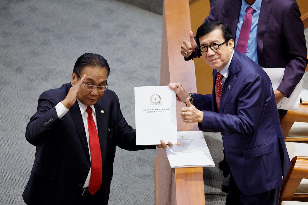 Yasonna Laoly, Indonesian Minister of Law and Human Rights, receives the new criminal code report from Bambang Wuryanto, head of the parliamentary commission overseeing the revision, during a parliamentary plenary meeting in Jakarta, Indonesia, December 6, 2022. REUTERS/Willy Kurniawan