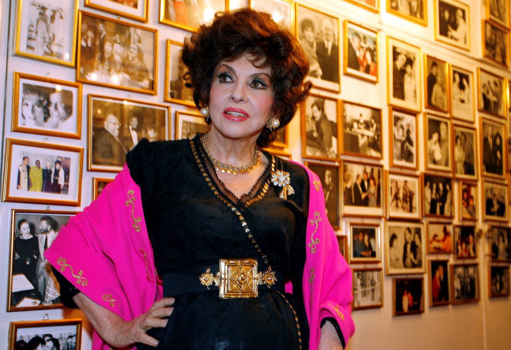 FILE PHOTO: Italian film icon Gina Lollobrigida poses near a wall of celebrity photos in her villa in southern Rome December 7, 2006.    REUTERS/Chris Helgren/File Photo