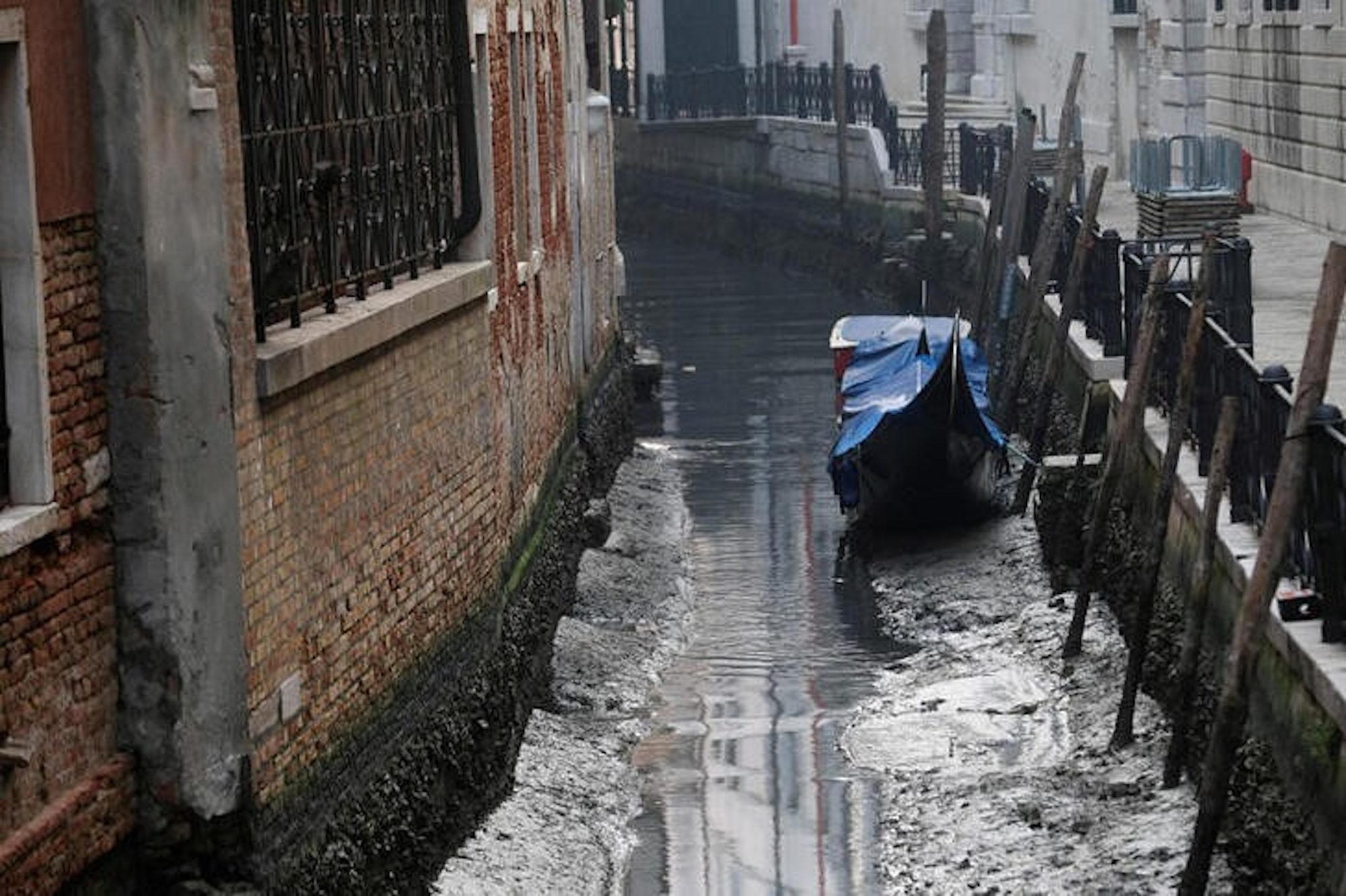 A gondola is pictured in a canal during a severe low tide in the lagoon city of Venice, Italy, February 17, 2023. REUTERS/Manuel Silvestri 
