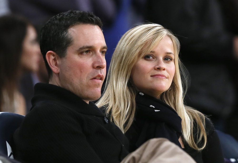 FILE PHOTO: Actress Reese Witherspoon (R) and her husband Jim Toth watch the Toronto Raptors play the Los Angeles Lakers in their NBA basketball game in Los Angeles, March 8, 2013.   REUTERS/Lucy Nicholson