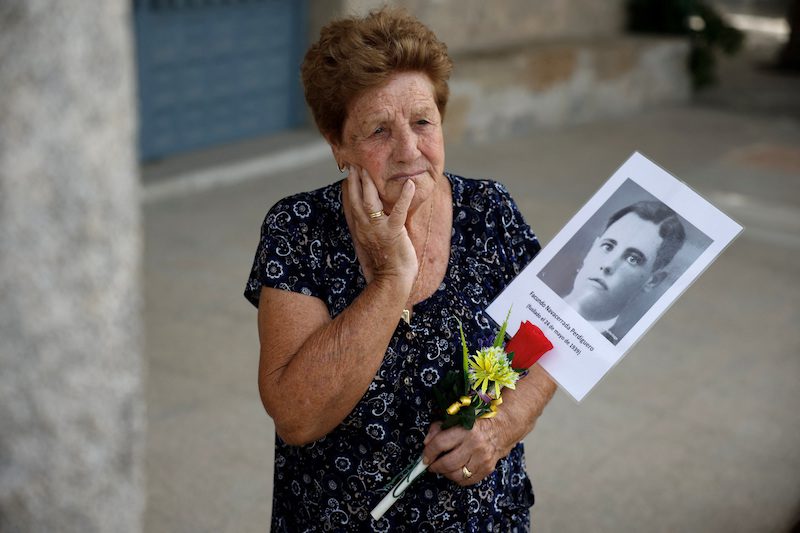 Benita Navacerrada Lopez holds a picture of her father Facundo Navacerrada Perdiguero who was one of the people who were killed by the forces of dictator Francisco Franco and for whom members of the Aranzadi Science Society are searching for in a mass grave in the Colmenar Viejo cemetery, Spain, August 9, 2023. REUTERS/Juan Medina