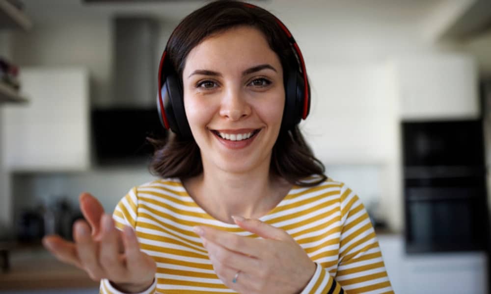 Woman on zoom call using headphones to learn a language
