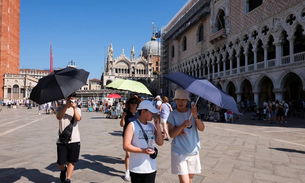 Tourists walk during a new heatwave as temperatures are expected to reach 40 degrees Celsius in some cities, in Venice, Italy August 22, 2023. REUTERS/Manuel Silvestri/File Photo