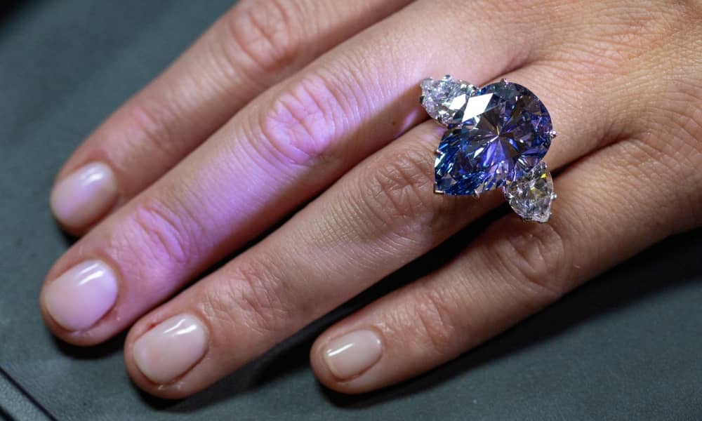 Christie’s Carola Chiadini holds the Bleu Royal diamond, weighing 17.61 carats. REUTERS/Denis Balibouse