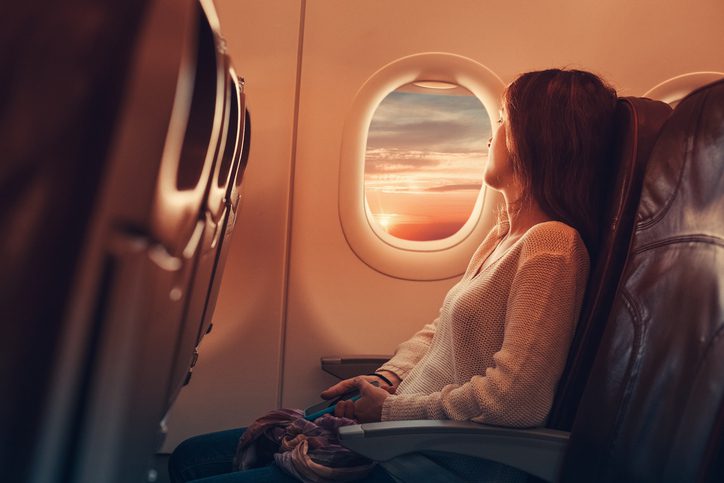 woman on airplane looking out window