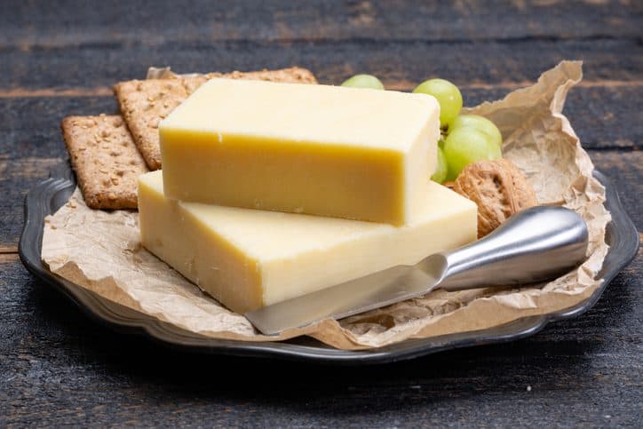 A block of aged cheddar cheese, the most popular type of cheese around the world