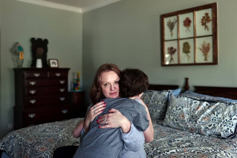 Kristia Rumbley hugs her eldest son in her bedroom, in Birmingham, Alabama, U.S