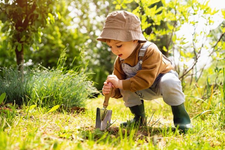 little boy gardening playing outside