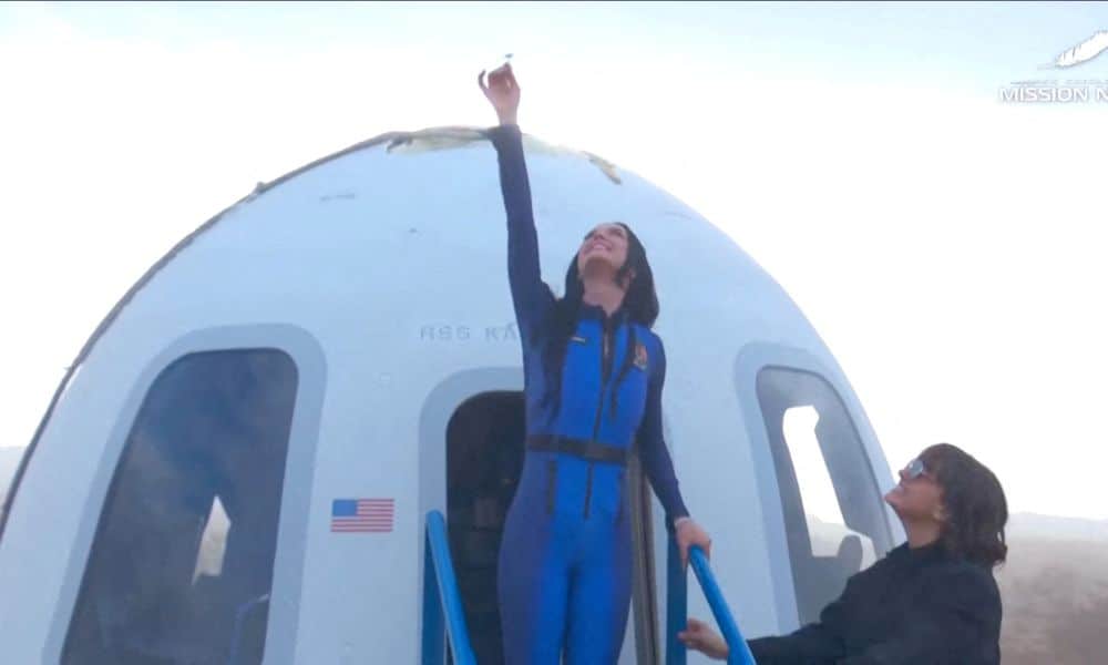 Pop star Katy Perry comes out of the capsule holding a daisy after landing back on earth after blasting off into space on a Blue Origin rocket. Photo / Blue Origin/Handout