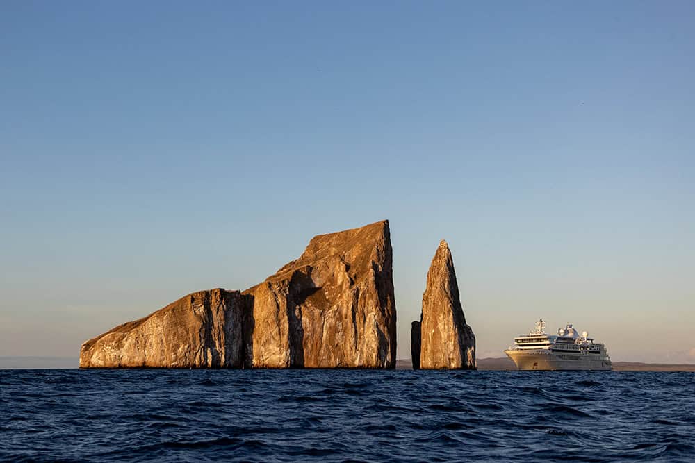 Silver Origin approaching Kicker Rock at sunset, Galapagos Islands.