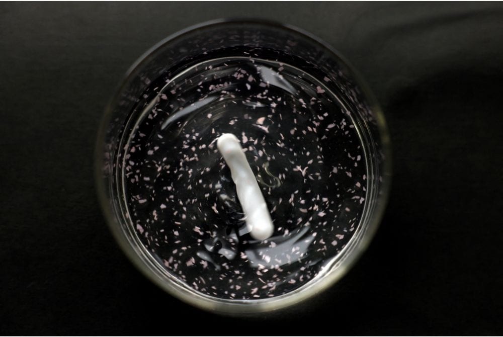 A sample of colored ocean-degradable plastic being stirred and dissolved in salty water. Photo / Reuters