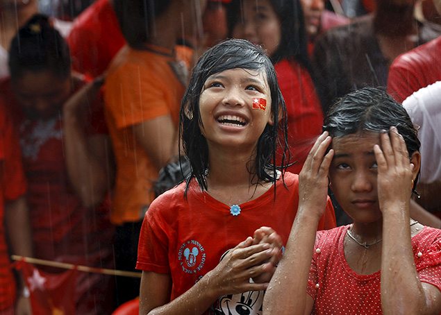 Supporters celebrate as they wait for official results from the Union Election Commission during heavy rain fall in front of the National League for Democracy Party (NLD) head office at Yangon. REUTERS/Soe Zeya Tun