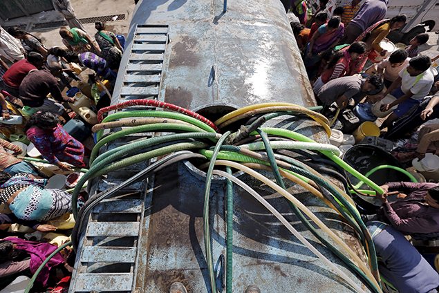 Residents with their empty containers crowd around a municipal tanker to fetch water in New Delhi, India.
REUTERS/Anindito Mukherjee