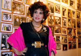 FILE PHOTO: Italian film icon Gina Lollobrigida poses near a wall of celebrity photos in her villa in southern Rome December 7, 2006.    REUTERS/Chris Helgren/File Photo