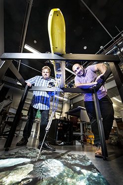 Pictured from left to right are Matt Dunbabin and Feras Dayoub with the COTSbot robot which is designed to search for and kill Crown of Thorns Starfish. Photo:QUT /Erika Fish. 