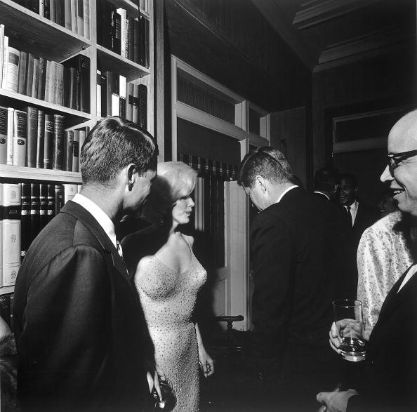 During a party at the home of movie executive Arthur Krim, American actress Marilyn Monroe stands between Robert Kennedy (left) and John F. Kennedy, New York, New York, May 19, 1962. The party followed a democratic fundraiser at Madison Square Garden honoring John F. Kennedy's birthday where Monroe famously sang "Happy Birthday.' (Photo by Cecil Stoughton/The LIFE Images Collection/Getty Images)