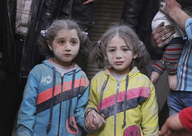 Girls who survived what activists said was a ground-to-ground missile attack by forces of Syria's President Bashar al-Assad, hold hands at Aleppo's Bab al-Hadeed district in  April 2015. REUTERS/Abdalrhman Ismail    