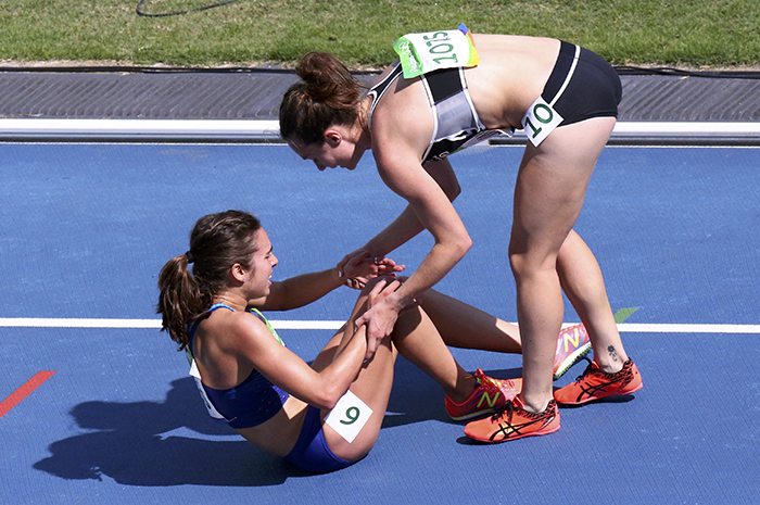Nikki Hamblin helps the injured Abbey D'Agostino to her feet after they fell in the women's 5000m heats. Photo Reuters