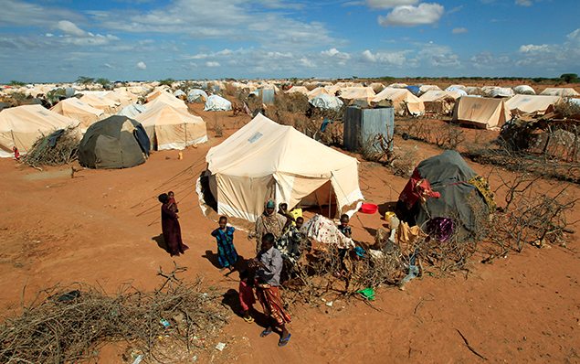 Refugees stand outside their tent at the Ifo Extension refugee camp in Dadaab,in this file photo. REUTERS/Thomas Mukoya