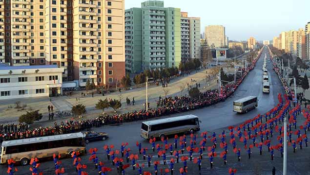People wave flags as members of operation team of Kwangmyongsong-4 long range rocket arrive at Pyongyang in this undated photo released by North Korea's Korean Central News Agency. REUTERS/KCNA 