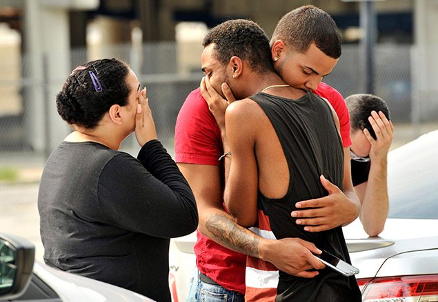 Friends and family members embrace outside the Orlando Police Headquarters during the investigation of a shooting at the Pulse night club.  REUTERS/Steve Nesius     