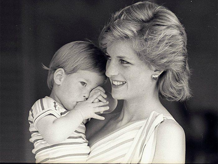 Young Prince Harry tries to hide behind his mother Princess Diana during a morning picture session at Marivent Palace on August 9, 1988. REUTERS/Hugh Peralta
