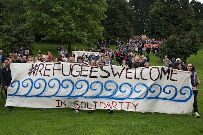 People carry a banner reading "#Refugees Welcome in solidarity" during a demonstration march in Aarhus, Denmark, September 12, 2015.  REUTERS/Sergey Polezhaka