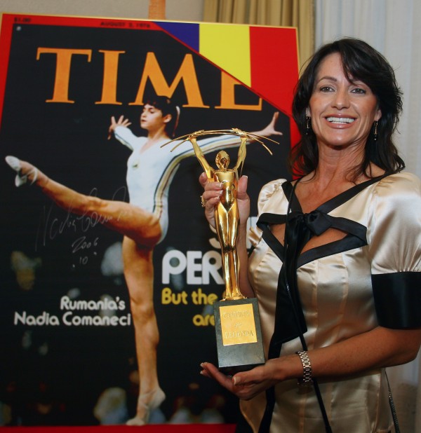 Romanian Olympic gold medal gymnast Comaneci holds the "Legendary Champions" trophy in Bucharest. REUTERS/Bogdan Cristel