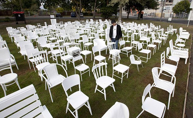 Artist Pete Majendie walks among his art installation of 185 white painted chairs which represent the 185 lives lost in the 2011 Christchurch earthquake. REUTERS/Simon Baker 