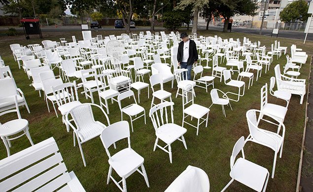 Artist Pete Majendie walks among his art installation of 185 white painted chairs which represent the 185 lives lost in the 2011 Christchurch earthquake. REUTERS/Simon Baker