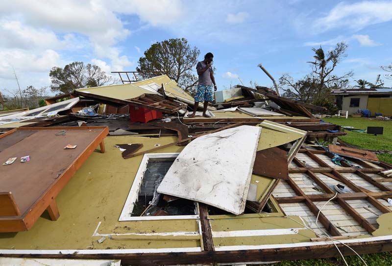 Local resident Adrian Banga looks at his home destroyed by Cyclone Pam in Port Vila, the capital city of the Pacific island nation of Vanuatu
