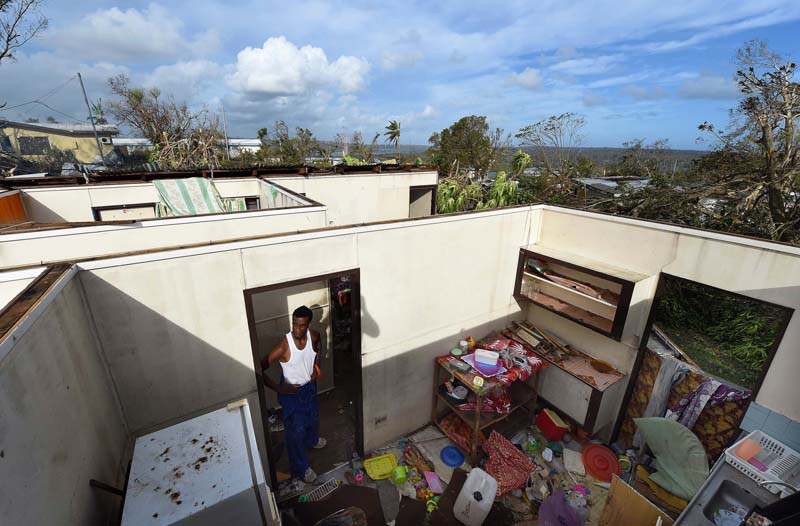 Local resident Uwen Garae stands in his home damaged by Cyclone Pam in Port Vila, the capital city of the Pacific island nation of Vanuatu