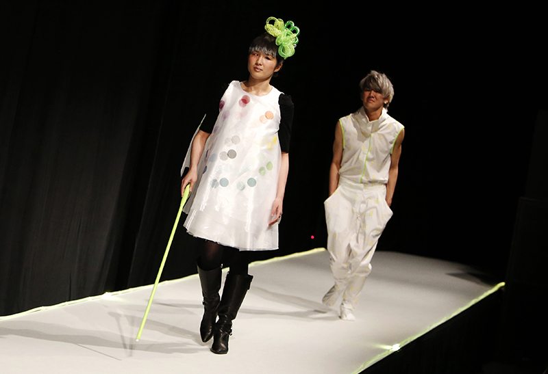 A visually impaired model (front), walks with a cane at Tenbo. 