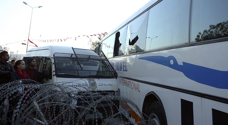 People look at a bus damaged by an attack by gunmen on Tunisia's national museum, in Tunis .