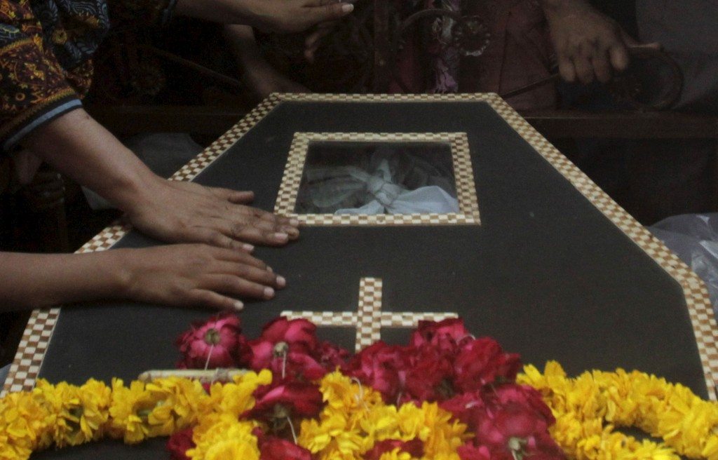 Family members touch a coffin of a relative, who was killed in a blast outside a public park on Sunday, during a funeral in Lahore. REUTERS/Mohsin Raza