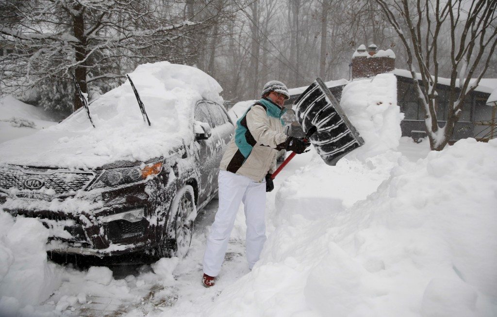 Heather Boos of Falls Church, Virginia, digs out her car. REUTERS/Kevin Lamarque