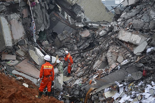 Firefighters search for survivors among the debris of collapsed buildings. REUTERS/Tyrone Siu      