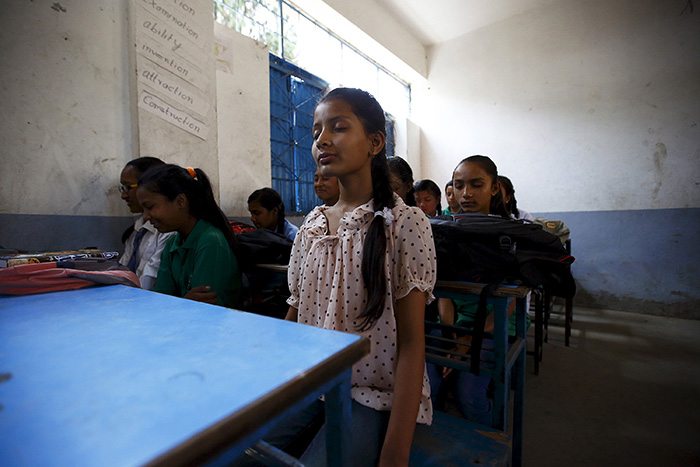 Children practice meditation in the classroom to ease their nerves. 