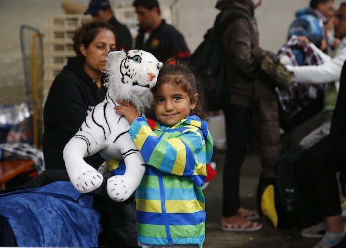 A young girl holds a teddy bear she received at the registration point for migrant arrivals at the main station in Munich, Germany September 5, 2015.             REUTERS/Michael Dalder  