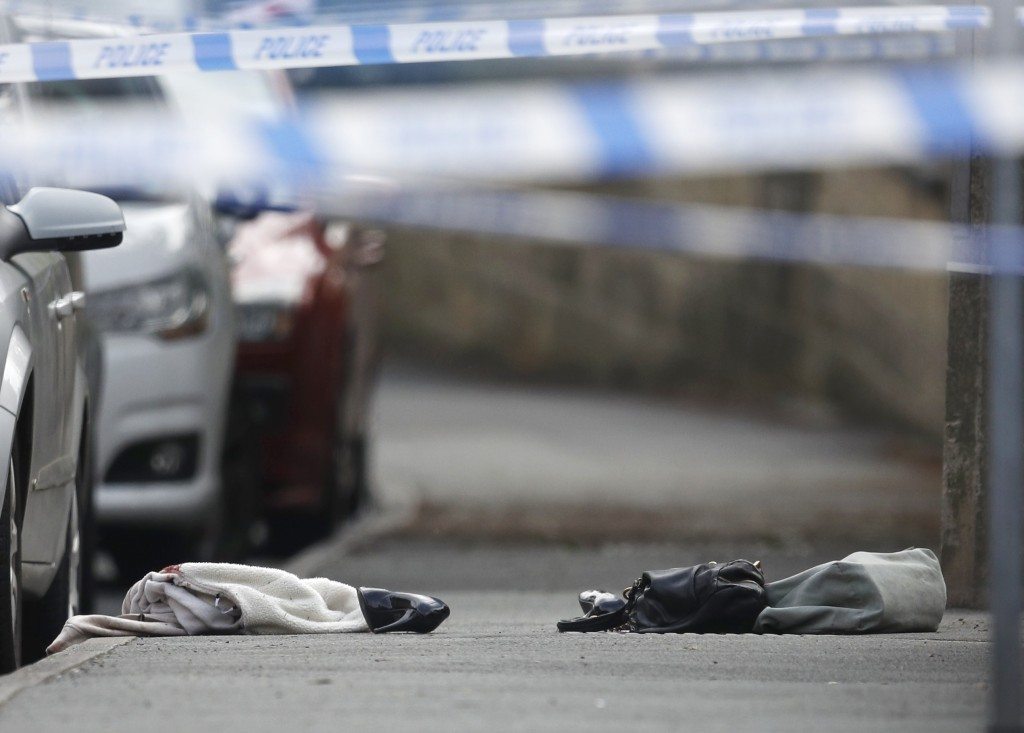 Women's shoes and a handbag lie on the ground behind a police cordon in Birstall near Leeds. REUTERS/Phil Noble 