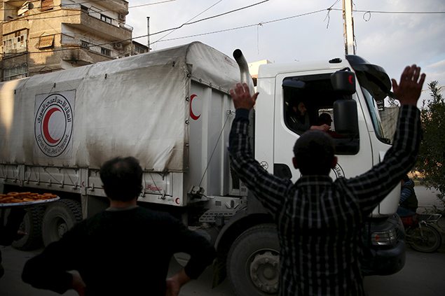 People welcome an aid convoy of Syrian Arab Red Crescent and United Nations. REUTERS/Bassam Khabieh